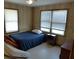 Bedroom with an airy feel featuring two windows, wood paneling, and a double bed at 1603 Lybrand St, Edisto Island, SC 29438