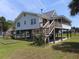Charming raised beach house with wooden stairs and screened in porch at 1603 Lybrand St, Edisto Island, SC 29438