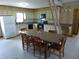 Functional kitchen featuring a dining table, appliances, and ladder access to loft at 1603 Lybrand St, Edisto Island, SC 29438