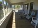 Relaxing screened porch with rocking chairs offers a place to enjoy the outdoors at 1603 Lybrand St, Edisto Island, SC 29438