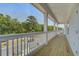 Spacious balcony with wooden floors and white railings overlooking the street and mature trees at 1619 Cultivation Ln, Mount Pleasant, SC 29466