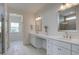 Bright bathroom featuring dual vanities, quartz countertop, and a tiled shower with glass door at 1619 Cultivation Ln, Mount Pleasant, SC 29466
