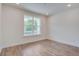 Empty bedroom with hardwood flooring, white trim, and a large window at 1619 Cultivation Ln, Mount Pleasant, SC 29466
