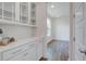 Butler's pantry featuring white cabinetry, quartz countertop, and wood flooring at 1619 Cultivation Ln, Mount Pleasant, SC 29466