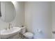 Well-lit powder room with modern fixtures including a pedestal sink, toilet, and round mirror at 1619 Cultivation Ln, Mount Pleasant, SC 29466
