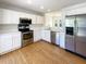 Well-lit kitchen features white cabinets, stainless steel appliances, quartz countertops, and hardwood floors at 1622 Pin Oak Cut, Mount Pleasant, SC 29466