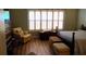 A comfortable bedroom with a cushioned chair, hard wood floors and abundant natural light at 1757 Wayah Dr, Charleston, SC 29414