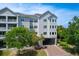 Exterior view of condo building with covered parking, landscaping, and multiple stories at 1984 Folly Rd # B114, Charleston, SC 29412