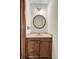 Powder room featuring a vanity with wood cabinets and an elegant round mirror at 204 Knightsbridge, Charleston, SC 29418