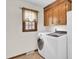 Convenient laundry room featuring a washer, dryer, wood cabinets and a window for natural light at 204 Knightsbridge, Charleston, SC 29418