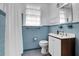 Retro bathroom with blue tiled walls and floors, and a white vanity with rounded mirror at 205 Tea Farm Rd, Summerville, SC 29483