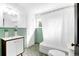 Retro bathroom with green tiled walls and floors, and a white vanity with a shower-tub combo at 205 Tea Farm Rd, Summerville, SC 29483