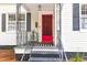 Close-up of the front door with a bright red finish, black hardware and striped welcome mat at 205 Tea Farm Rd, Summerville, SC 29483