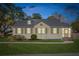 Charming single-story home featuring light yellow siding, dark shutters, and a brick chimney at dusk at 2178 Fort Pemberton Dr, Charleston, SC 29412