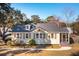 Charming home featuring light yellow siding, gray shingles, a brick chimney, and a cozy screened in porch at 2178 Fort Pemberton Dr, Charleston, SC 29412
