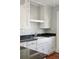 White kitchen cabinets, black countertops and a farmhouse sink with a stainless steel faucet at 2178 Fort Pemberton Dr, Charleston, SC 29412