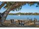 Scenic waterfront view featuring benches, a tranquil river, lush trees, and a sailboat in the background at 2178 Fort Pemberton Dr, Charleston, SC 29412