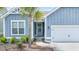 Front entry with a blue door, an adjacent garage, and a nicely landscaped flower bed at 221 Seaworthy St, Summerville, SC 29486