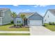 Charming single-Gathering home with two palm trees, an attached two-car garage, and beautiful blue siding at 221 Seaworthy St, Summerville, SC 29486