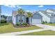 Charming single-Gathering home with two palm trees, an attached two-car garage, and beautiful blue siding at 221 Seaworthy St, Summerville, SC 29486