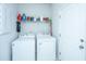 Bright, clean laundry room equipped with white washer and dryer units and overhead storage at 224 Hayworth Rd, Summerville, SC 29486