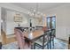 Formal dining room with a large wooden table, elegant chandelier, artwork and chair rail at 2269 Hartfords Bluff Cir, Mount Pleasant, SC 29466