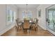 Bright dining room featuring a wood table, chairs, large windows with shutters and stylish chandelier at 2269 Hartfords Bluff Cir, Mount Pleasant, SC 29466