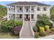 Beautiful two-story home featuring double porches, white railings, and a meticulously landscaped front yard at 2269 Hartfords Bluff Cir, Mount Pleasant, SC 29466