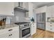 Modern kitchen featuring stainless steel appliances, white cabinets, and a stylish gray backsplash at 2269 Hartfords Bluff Cir, Mount Pleasant, SC 29466