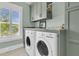 Functional laundry room equipped with modern washer and dryer, ample counter space and storage cabinets at 2269 Hartfords Bluff Cir, Mount Pleasant, SC 29466