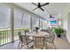 Spacious screened porch featuring a dining table, comfortable seating, ceiling fans, and scenic views at 2269 Hartfords Bluff Cir, Mount Pleasant, SC 29466