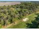 An aerial view of the home nestled within mature trees next to a golf course at 2355 Andell Way, Seabrook Island, SC 29455