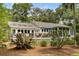 A home's rear exterior with deck seating and beautiful natural backyard landscaping at 2355 Andell Way, Seabrook Island, SC 29455