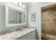 Bright bathroom featuring a granite countertop, a large mirror, and a shower with a glass door at 2355 Andell Way, Seabrook Island, SC 29455