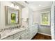 Bathroom featuring white cabinets, granite countertops, large framed mirror, and a window overlooking the landscape at 2355 Andell Way, Seabrook Island, SC 29455