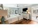 Light-filled bedroom featuring hardwood floors, a ceiling fan, and an en-suite bathroom at 2355 Andell Way, Seabrook Island, SC 29455