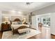 Spacious main bedroom featuring a decorative rug, a bed with a cushioned bench, and doors to the outdoor patio at 2355 Andell Way, Seabrook Island, SC 29455