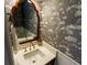 Stylish powder room with floral wallpaper, decorative mirror, modern faucet, and white wainscoting at 24 Archdale St, Charleston, SC 29401