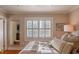 Sunlit bedroom with a large window with plantation shutters, soft bedding, and mirror at 24 Archdale St, Charleston, SC 29401