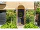 An inviting front entrance with lush greenery, a wreath, elegant sconces, and a black door at 24 Archdale St, Charleston, SC 29401
