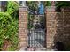 Ornate wrought iron gate leading to a tranquil outdoor area with lush foliage at 24 Archdale St, Charleston, SC 29401