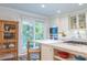 Eat-in kitchen features white cabinets, marble counters, stainless appliances, and a sliding door to a balcony at 24 Archdale St, Charleston, SC 29401