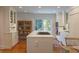 Spacious eat-in kitchen with white cabinets, marble countertops, island cooktop, and sunny sliding door to balcony at 24 Archdale St, Charleston, SC 29401