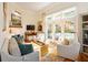 Bright living room with hardwood floors, white sofas, fireplace, and French doors leading to a patio at 24 Archdale St, Charleston, SC 29401