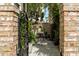 Inviting patio area with table and chairs viewed through an ornate wrought-iron gate at 24 Archdale St, Charleston, SC 29401