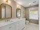 Elegant bathroom with double vanities, and decorative mirrors over a marble countertop at 2802 Ion Ave, Sullivans Island, SC 29482