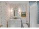 Charming bathroom with floral wallpaper, white vanity with marble top, and shower with blue tile at 2802 Ion Ave, Sullivans Island, SC 29482