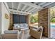 Relaxing covered patio with brick floor, comfortable seating, and views of the yard at 2802 Ion Ave, Sullivans Island, SC 29482