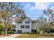 Two-story home with double porches, dark shutters, a garage and well-kept landscaping at 2802 Ion Ave, Sullivans Island, SC 29482