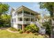 Charming home featuring a double porch, lush landscaping, and an inviting staircase at 2802 Ion Ave, Sullivans Island, SC 29482